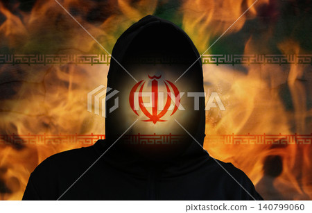 Iran state terrorism and war concept with anonymous hooded silhouette on burning Iranian flag background. Terrorist threat, military conflict or geopolitical danger metaphor 140799060