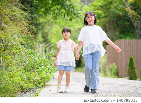 Two close sisters taking a walk in the park Two close sisters taking a walk in the park 140799315