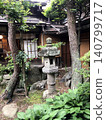 Stone lanterns in a Japanese garden and a view of the courtyard of an old farmhouse. 140799717
