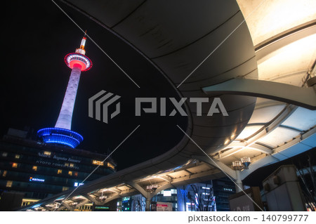 Kyoto tower at night from Kyoto Station`s bus terminal curve roof Kyoto tower at night from Kyoto Station`s bus terminal curve roof 140799777