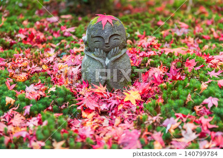 Jizo stone Buddha sculpture and autumn maple leaf, Enkoji temple, Kyoto Jizo stone Buddha sculpture and autumn maple leaf, Enkoji temple, Kyoto 140799784