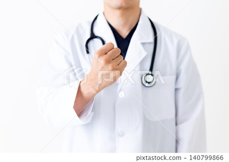 A middle-aged male doctor in a white coat makes a triumphant gesture. A middle-aged male doctor in a white coat makes a triumphant gesture. 140799866