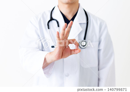 A middle-aged male doctor in a white coat making a circular pose. A middle-aged male doctor in a white coat making a circular pose. 140799871