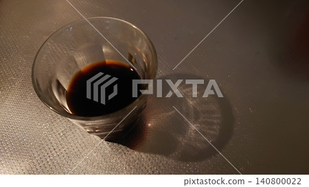 A black liquid in a glass and a shadow A black liquid in a glass and a shadow 140800022