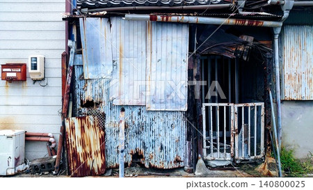 The appearance of an old, dilapidated house with corrugated iron walls. The appearance of an old, dilapidated house with corrugated iron walls. 140800025