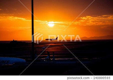 一架客機在美麗的夕陽和跑道的襯托下，緩緩起飛，場面十分壯觀。 140800593