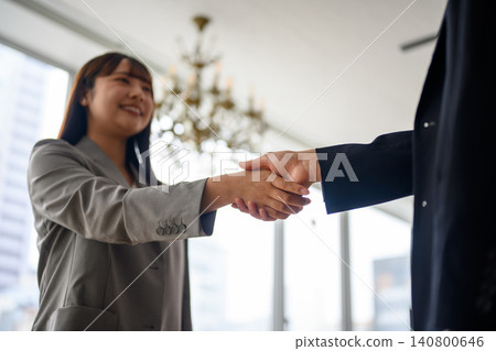 A young woman shakes hands in the office. 140800646
