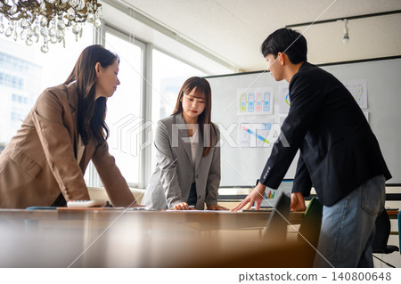 Men and women from a business team discussing in a conference room Men and women from a business team discussing in a conference room 140800648