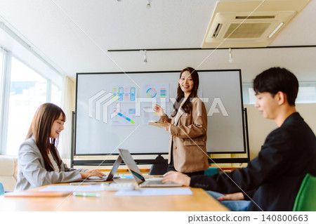 A female presenter smiles at the meeting. A female presenter smiles at the meeting. 140800663