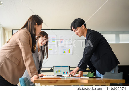 A business team discussing things around a laptop. A business team discussing things around a laptop. 140800674