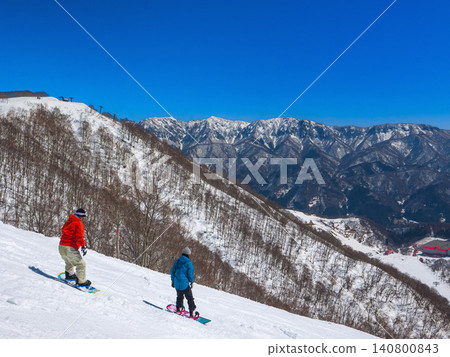 一名單板滑雪者站在白馬科爾蒂納滑雪場(長野縣小谷村)的陡坡上。 一名單板滑雪者站在白馬科爾蒂納滑雪場(長野縣小谷村)的陡坡上。 140800843