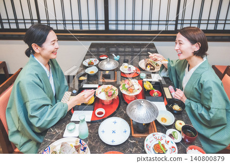 A woman in a yukata eating at an inn 140800879