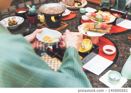 A woman in a yukata eating at an inn A woman in a yukata eating at an inn 140800881