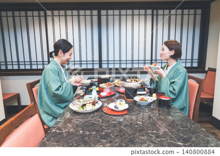 Middle-aged woman eating at a Japanese inn Middle-aged woman eating at a Japanese inn 140800884