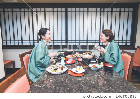 Middle-aged woman eating at a Japanese inn 140800885