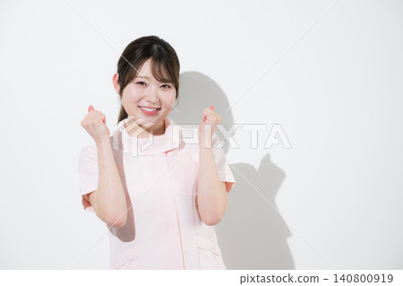 想像一下,一位穿著粉紅色護士服的美容護士、牙科保健員或牙科助理,面帶微笑,歡呼雀躍,擺出勝利的姿勢。 想像一下,一位穿著粉紅色護士服的美容護士、牙科保健員或牙科助理,面帶微笑,歡呼雀躍,擺出勝利的姿勢。 140800919