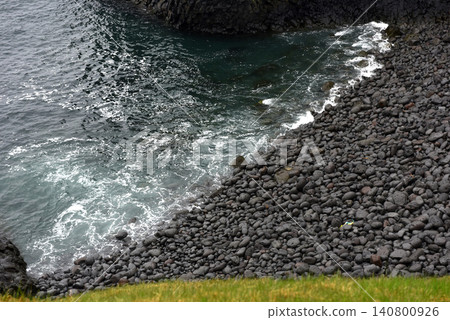 Black basalt pebble beach lined by dark ocean waves at Arnarstapi, Iceland Black basalt pebble beach lined by dark ocean waves at Arnarstapi, Iceland 140800926