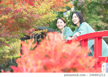 兩名身穿浴衣(日本傳統夏季和服)的女子麵帶微笑,欣賞著風景。 兩名身穿浴衣(日本傳統夏季和服)的女子麵帶微笑,欣賞著風景。 140801211