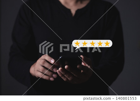 Customer Review, Young Man hand holding Smart Phone with five star to review and give 5 stars Customer Review, Young Man hand holding Smart Phone with five star to review and give 5 stars 140801553