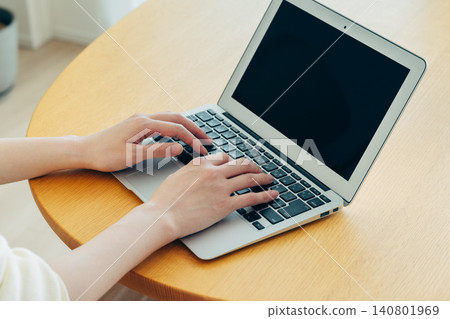 A young woman's hands as she uses her computer at home A young woman's hands as she uses her computer at home 140801969