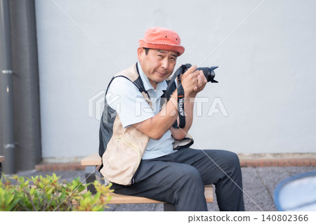 A man smiling with a camera in his hand. A man smiling with a camera in his hand. 140802366