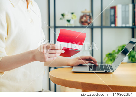 A young woman checks her bank account on her computer. A young woman checks her bank account on her computer. 140802394