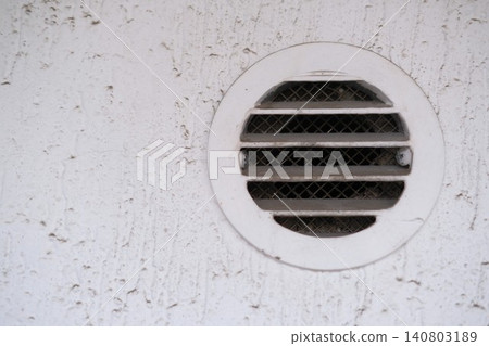 White round dirty and dusty air vent panel on wall of residential building. Ventilation and temperature regulation. Maintenance of household, interior or exterior air grille. Cleaning services White round dirty and dusty air vent panel on wall of residential building. Ventilation and temperature regulation. Maintenance of household, interior or exterior air grille. Cleaning services 140803189