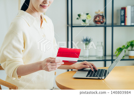 A young woman checks her bank account on her computer. A young woman checks her bank account on her computer. 140803984