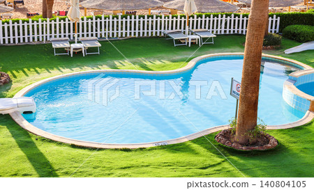 Small shallow children's pool at a sunny resort with colorful surroundings and lounge chairs nearby Small shallow children's pool at a sunny resort with colorful surroundings and lounge chairs nearby 140804105