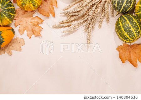 Autumn still life with pumpkins and leaves on beige background 140804636