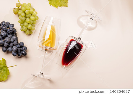 Wine glasses and grapes on beige background Wine glasses and grapes on beige background 140804637