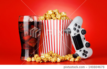 Popcorn, cola and gamepad on red background Popcorn, cola and gamepad on red background 140804678