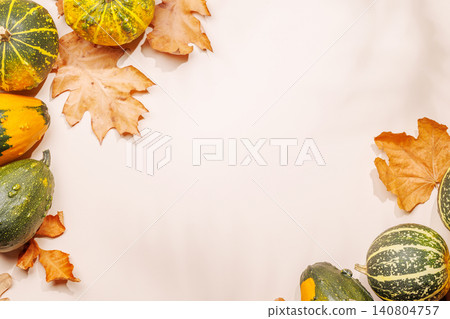 Autumn still life with pumpkins and leaves on beige background Autumn still life with pumpkins and leaves on beige background 140804757