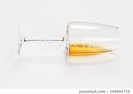 Wine glass with white wine lying on white background Wine glass with white wine lying on white background 140804758