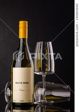 White wine bottle and glasses on dark background White wine bottle and glasses on dark background 140804840