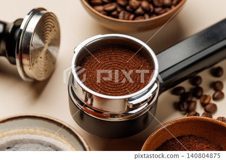 Close up of fresh ground coffee in portafilter for espresso machine Close up of fresh ground coffee in portafilter for espresso machine 140804875
