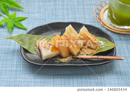 葛粉麻糬盛於竹葉上，淋上黃豆粉和紅糖漿。 140805434