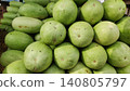 Fresh long green watermelons arranged in stacked market piles 140805797