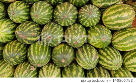 Fresh striped watermelons displayed in busy fruit market 140805798