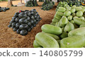 Fresh watermelon piles beside a grassy market path 140805799