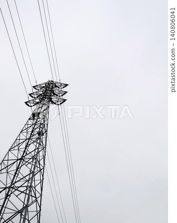 A transmission tower stands against a cloudy sky. Suitable for infrastructure inspections, energy issues, or as a nostalgic background image. A transmission tower stands against a cloudy sky. Suitable for infrastructure inspections, energy issues, or as a nostalgic background image. 140806041
