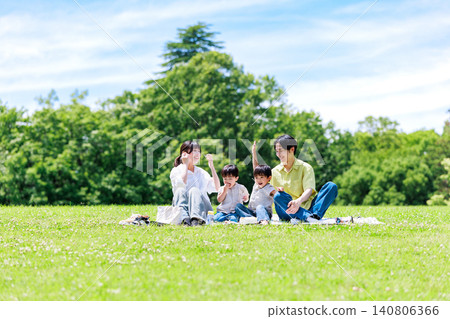 一家人在綠草茵茵的公園野餐。 一家人在綠草茵茵的公園野餐。 140806366