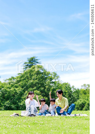 A family having a picnic in a grassy park. A family having a picnic in a grassy park. 140806611