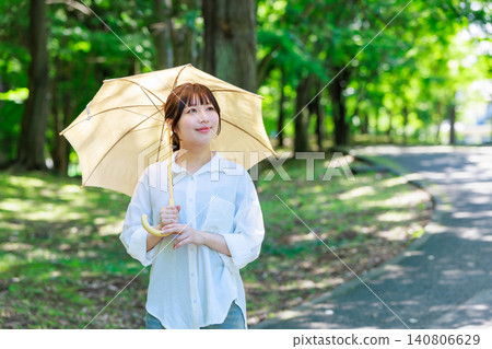 拿著遮陽傘的一個少婦 拿著遮陽傘的一個少婦 140806629