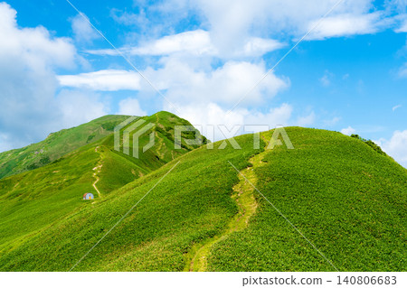 A green carpet: refreshing ridgelines and trails stretching towards the summer blue sky. A green carpet: refreshing ridgelines and trails stretching towards the summer blue sky. 140806683