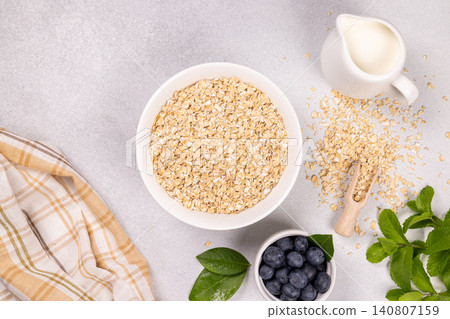 Preparing healthy breakfast with oats, blueberries, and milk 140807159