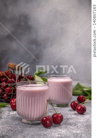 Cherry yogurt smoothie glasses on gray background Cherry yogurt smoothie glasses on gray background 140807163