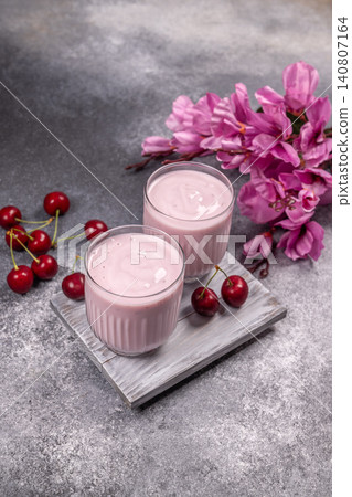 Cherry yogurt smoothie glasses on wooden board Cherry yogurt smoothie glasses on wooden board 140807164