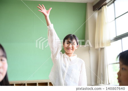 Elementary school children enthusiastically raising their hands to participate in class (fun lesson, active learning) 140807640
