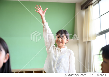 Elementary school children enthusiastically raising their hands to participate in class (fun lesson, active learning) 140807641